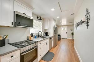 une cuisine avec des armoires blanches et un four à plaques de cuisson dans l'établissement Entire 2 bedroom Pet Friendly Guest Cottage, à Alpine