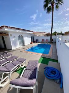 una villa con piscina y tumbonas en Villa One Tenerife, en Costa del Silencio