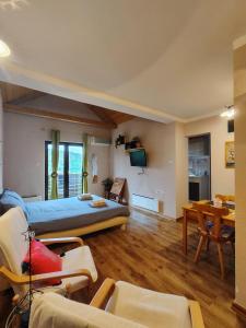 a bedroom with a bed and a living room at Madora - Studio Apartman in Fužine