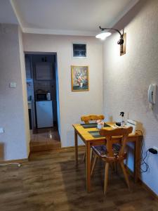 a kitchen with a wooden table and a table and chair at Madora - Studio Apartman in Fužine