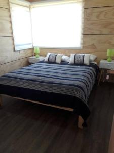 1 dormitorio con 1 cama grande y 2 ventanas en Cabañas Berner #2 (5 personas), en Puerto Varas
