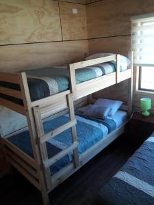 1 dormitorio con 2 literas con sábanas azules en Cabañas Berner #2 (5 personas), en Puerto Varas
