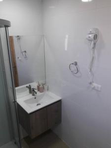 Baño blanco con lavabo y espejo en Cabañas Berner #2 (5 personas), en Puerto Varas