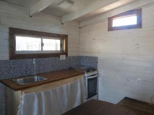 Il comprend une petite cuisine équipée d'un évier et d'une cuisinière. dans l'établissement Shanti, à Neptunia