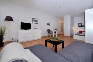 a living room with a couch and a tv and a table at Hotel Friedrichstraße in Lampertheim