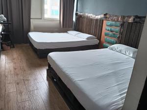 two twin beds in a room with at OYO 90863 Hi Inn 2 in Sibu