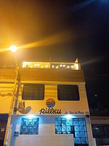een gebouw met een bord aan de zijkant 's nachts bij Pillku Hospedaje in Huarmey