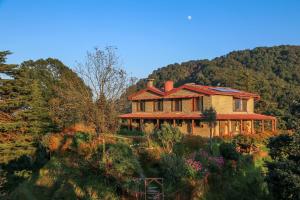 a large brick house in the middle of a forest at Nine Furlongs, Binsar Wildlife Sanctuary in Almora