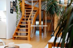 a wooden staircase in a living room with a plant at White Loft in the Riga City Center in Rīga