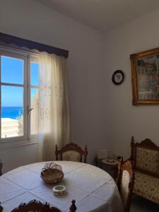 a bedroom with a table with a view of the ocean at Mare Blu Sole in Karpathos Town