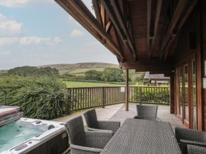 a deck with chairs and a hot tub on a house at Pine in Swanage