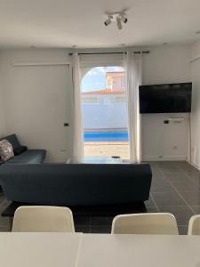 Una sala de estar con un sofá y una ventana grande. en Villa One Tenerife, en Costa del Silencio