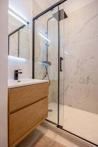 a bathroom with a glass shower and a sink at La Perle Citadine En Hyper Centre in La Rochelle