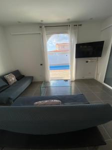 salon z kanapą i dużym oknem w obiekcie Villa One Tenerife w mieście Costa Del Silencio