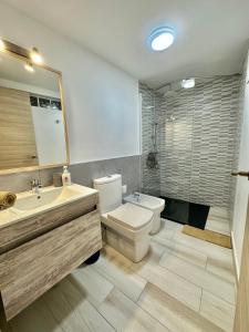 a bathroom with a toilet and a sink and a mirror at Cotillo Sol en el centro del Cotillo, 1 minuto de la playa, 2 habitaciones, terraza y WIFI in Cotillo
