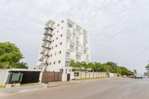 un edificio blanco alto al lado de una calle en Accra Luxury Apartments @ Pine Court en Cantonments