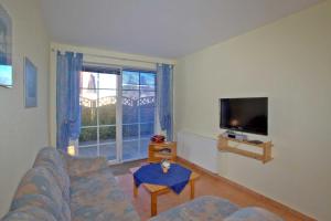 ein Wohnzimmer mit einem Sofa und einem TV in der Unterkunft Ferienwohnungen 300 m zum Strand in Glowe