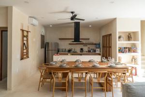 cocina y comedor con mesa de madera y sillas en Villa Saadhu with fantastic oceanview en Isla Mujeres