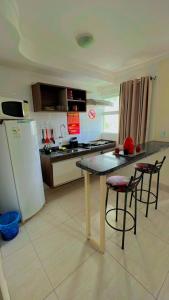 eine Küche mit einem Tisch und Stühlen sowie einem Kühlschrank in der Unterkunft Flat Diroma Lacqua in Caldas Novas