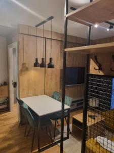 uma sala de jantar com uma mesa e um beliche em Divcigora Apartman E&N em Divčibare