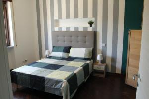1 dormitorio con 1 cama con pared a rayas en Capital House Roma, en Roma