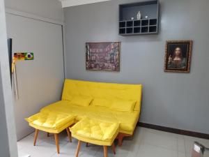 um sofá amarelo num quarto com duas cadeiras amarelas em Apartamento Completo e Aconchegante em Lagoa Santa