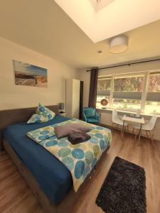 a bedroom with a bed and a table and a desk at Apartmenthaus am Park in Wilhelmshaven