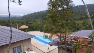 een afbeelding van een zwembad in een huis bij Lindo chalé no alto da colina, vista paradisíaca do por do sol, proximo a praia e cachoeiras in Pariqueraçu