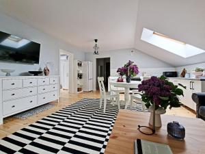 a kitchen and living room with a table and purple flowers at Karczma Ostoya in Jasionka