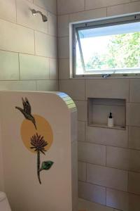 a bathroom with a flower painted on the side of a tub at Lovely studio-apartment near the beach in Uvita