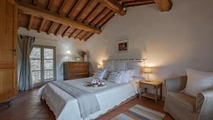 a bedroom with a large bed and a chair at L'Agrifoglio in Gaiole in Chianti