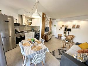 kuchnia i salon ze stołem i krzesłami w obiekcie Candy Cotton - Piscina, Doble terraza, Cocina completa, Wifi y Parking w Corralejo