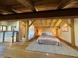 sypialnia z dużym łóżkiem i drewnianym sufitem w obiekcie Luxury penthouse apartment w mieście Essert-Romand