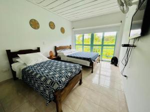 sypialnia z 2 łóżkami i telewizorem z płaskim ekranem w obiekcie La Posada Circa w mieście Montenegro