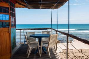 uma mesa e cadeiras numa varanda com vista para a praia em Hosteria Farallon Dillon em Ballenita
