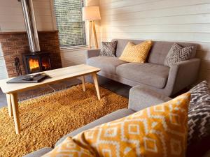 ein Wohnzimmer mit einem Sofa und einem Couchtisch in der Unterkunft Kinnaird Woodland Lodges in Pitlochry