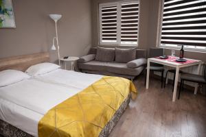 a bedroom with a bed and a couch and a table at All Seasons Apartments Iglika 2 in Borovets