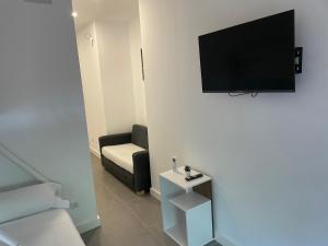 een woonkamer met een bank en een televisie aan de muur bij C3 Exclusiva zona Madrid in Madrid