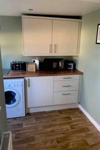 a kitchen with a washing machine and a washer at Cosy Cottage, Nr Betws y Coed. in Llanrwst