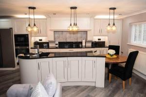 a kitchen with white cabinets and a table and a counter at Little Retreat in Woodhouse