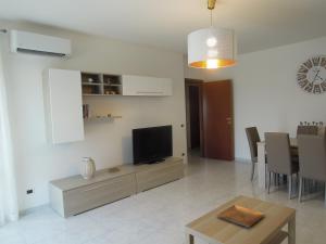 ein Wohnzimmer mit einem Flachbild-TV und einem Tisch in der Unterkunft Casa di RO' in Taranto