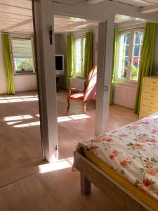 a bedroom with a bed and a chair and windows at B&B tannen124 in Oberburg