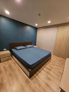 a bedroom with a bed and a blue wall at Bangkok Sukhumvit Ekkamai Thonglor The ACE in Bangkok