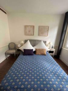 a bedroom with a blue bed with pillows on it at Ravissante maison de pêcheurs Trouville proche centre et gare in Trouville-sur-Mer