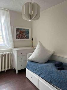 a bedroom with a bed and a dresser with a pillow at Ravissante maison de pêcheurs Trouville proche centre et gare in Trouville-sur-Mer