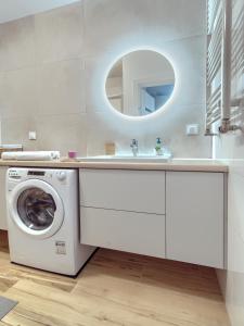 a bathroom with a washing machine and a sink at Tricity Retreat Apartments with Parking - by Rentujemy in Straszyn +8 photos