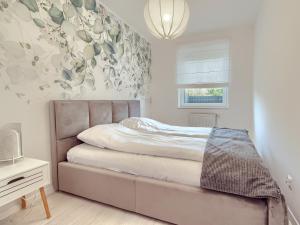 a bedroom with a bed and a flower wall at Tricity Retreat Apartments with Parking - by Rentujemy in Straszyn