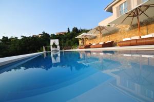 einen Pool mit blauem Wasser vor einem Haus in der Unterkunft Zeno Suites in San Zeno di Montagna