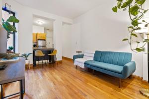 ein Wohnzimmer mit einem blauen Sofa und einer Küche in der Unterkunft Central Living at Columbia university in New York