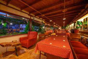 un restaurante con sillas rojas, mesa y sillas en Cesmeli Konak Garden, en Safranbolu